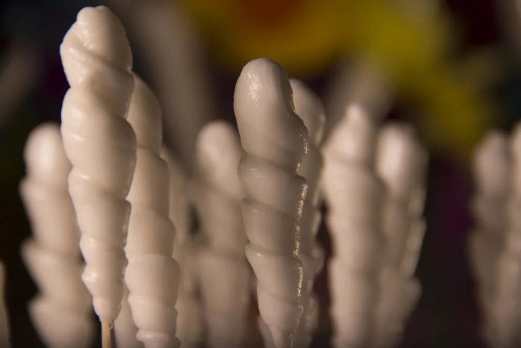Dulces entorchados de alfeñique sobre una mesa de trabajo artesanal