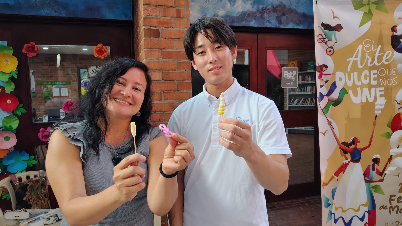 Dos participantes comparten dulces de alfeñique durante un encuentro en Cali